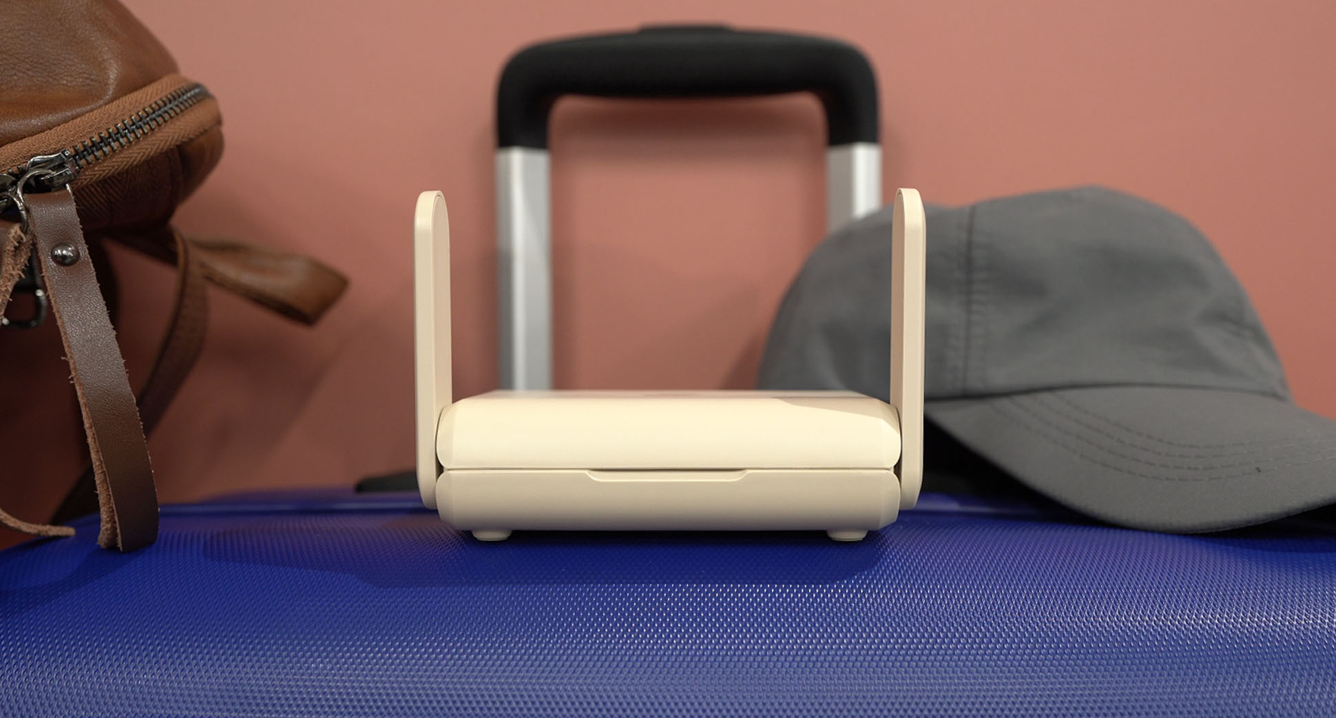 Aircove Go on a suitcase and next to luggage bag